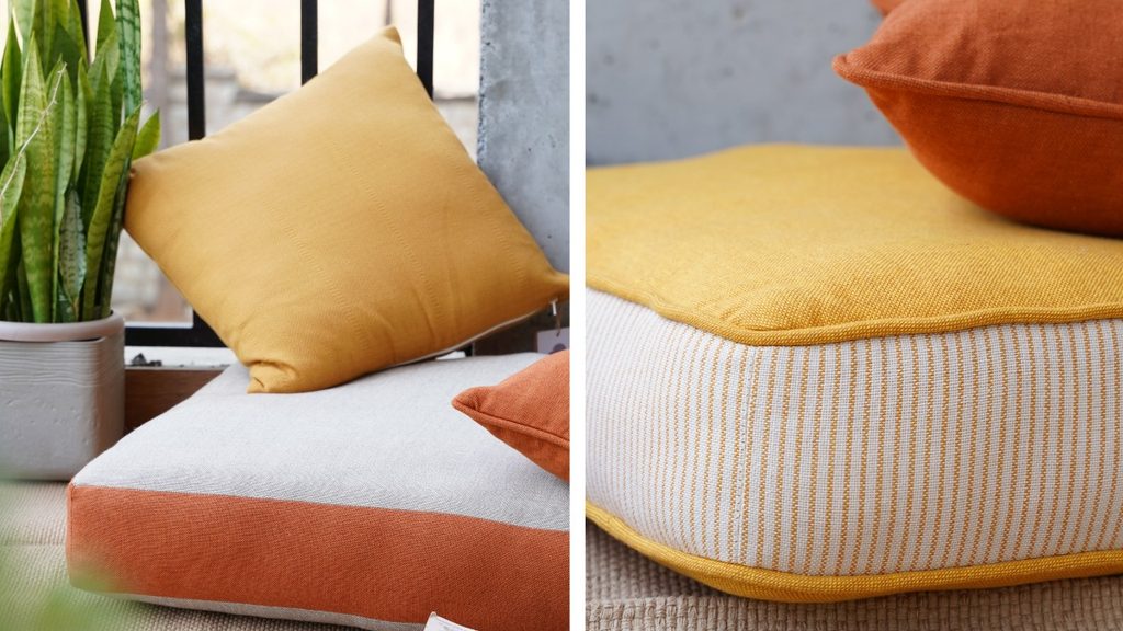 Floor cushions on a balcony with a rug, low wooden table and plants